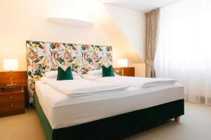 a bedroom with a large bed with a floral headboard at Hotel Kaiserhof Wien in Vienna