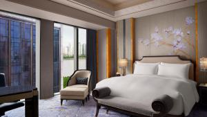 上海市にあるThe St. Regis on the Bund, Shanghaiのベッドルーム1室(ベッド1台、椅子、窓付)