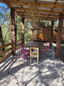 a wooden table and chairs under a wooden pergola at Cabaña Win en el Bosque, RUNA YAKU in San Lorenzo