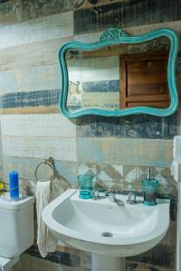 a bathroom with a sink and a mirror and a toilet at Cabaña Win en el Bosque, RUNA YAKU in San Lorenzo