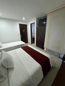 um quarto grande com uma grande cama branca em Hotel Ipanema Meridian em Neiva