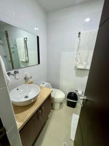 uma casa de banho com um lavatório, um WC e um espelho. em Hotel Ipanema Meridian em Neiva