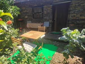 d'une terrasse avec une table et des chaises dans le jardin. dans l'établissement Casa do Pastor, à Lousã