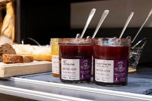 two jars of jam sitting on a counter with bread at Campanile Metz Nord - Talange in Talange