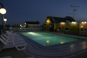 einen Swimmingpool mit Stühlen und einem Gebäude in der Unterkunft Residence Cristoforo Colombo in Caorle