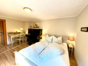 a bedroom with a white bed and a piano at Land & Leben Pension in Chemnitz