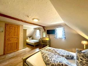 a bedroom with two beds and a room with a desk at Land & Leben Pension in Chemnitz