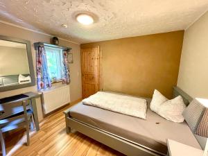 a small bedroom with a bed and a desk at Land & Leben Pension in Chemnitz