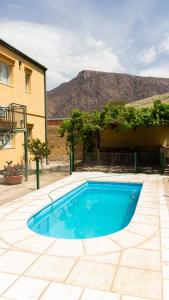 una piscina azul frente a un edificio en Departamentos PASEO DE LAS VIÑAS, CAFAYATE, en Cafayate