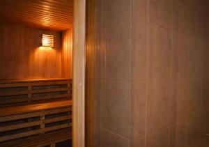 a sauna with a walk in shower next to a door at Guesthouse & sauna by HMTL in Liepāja