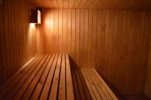 a wooden bench in a sauna with a light at Guesthouse & sauna by HMTL in Liepāja