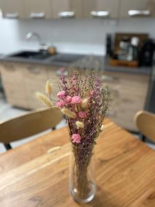 een vaas gevuld met roze bloemen zittend op een tafel bij Loket Island in Loket