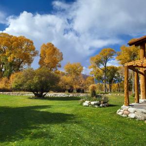 einen Garten mit einer Steinmauer und Bäumen in der Unterkunft BuffaloPeaks Lodge in Buena Vista