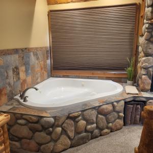 eine große Badewanne in einem Zimmer mit Fenster in der Unterkunft BuffaloPeaks Lodge in Buena Vista