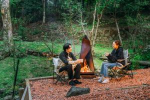 Quelques personnes assises autour d'un feu dans l'établissement koti hakone（コティ箱根）, à Hakone