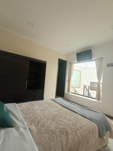 a bedroom with a large bed with a large window at HOTEL El MONARCA in Tunja