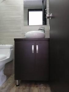 a bathroom with a sink and a mirror and a toilet at HOTEL El MONARCA in Tunja