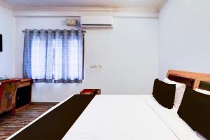 a white bed in a room with a window at Hotel O VG Grand in Madhapur