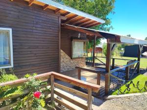 Cabaña de madera con porche y terraza en Cabañas El Tronco Viejo, en Curacautín