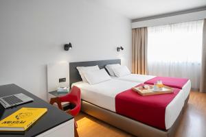 A bed or beds in a room at Hotel Amadeos - Matosinhos - Porto