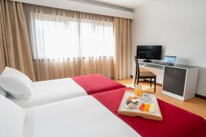 A bed or beds in a room at Hotel Amadeos - Matosinhos - Porto