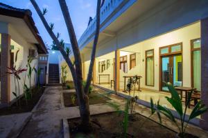 un patio de una casa con una palmera en Kidi's Lodge Gilitrawangan, en Gili Trawangan