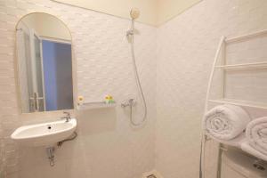 a white bathroom with a sink and a shower at Baliem CoLiving in Jimbaran