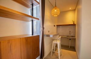 a kitchen with a counter and a stool in a room at Baliem CoLiving in Jimbaran