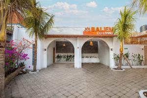 a building with palm trees and a sign on it at Baliem CoLiving in Jimbaran