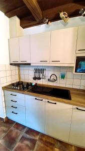 a kitchen with white cabinets and a stove top oven at Harmony Vendégház Egerszalók in Egerszalók