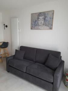 eine schwarze Couch in einem Wohnzimmer mit einer Statue in der Unterkunft studio indépendant in Rochefort