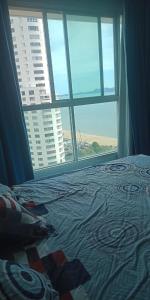 a bed in a room with a large window at 1bedroom seaview ห้องวิวทะเล ชั้น28 premium highfloorวิ in Jomtien Beach