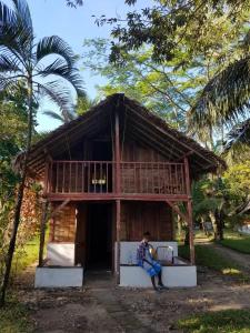 uma pessoa sentada num sofá em frente a uma casa em MAHAMBO BEACH hôtel em Mahambo