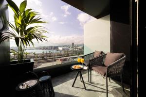 d'un balcon avec une table, des chaises et une grande fenêtre. dans l'établissement Hotel Puerto de la Luz by Pierre & Vacances, à Las Palmas de Gran Canaria