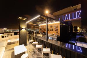 - un bar avec des tables et des chaises blanches la nuit dans l'établissement Hotel Puerto de la Luz by Pierre & Vacances, à Las Palmas de Gran Canaria