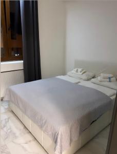 Una cama blanca con dos toallas encima. en Aurelia apartman, en Vinkovci