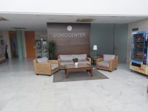 a lobby with chairs and a table in a building at Domocenter Apartamentos Turísticos in Bormujos