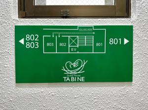 a sign for a tba bine on a wall at TABINE 1min walk to Station Prime Location in Kumamoto