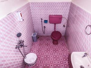 un bagno rosa con servizi igienici e lavandino di BOB's Heaven Bungalow a Ooty