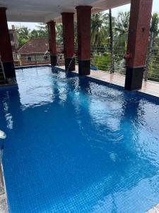 een groot zwembad met blauw water bij Sportsman Apartment in Calangute