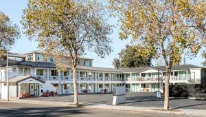 een groot wit gebouw met bomen ervoor bij Leland Hotel Palo Alto in Palo Alto