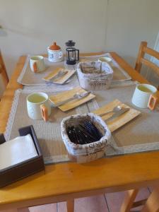 - une table en bois avec des tasses et des ustensiles dans l'établissement La casona de don Juan, à Coyhaique