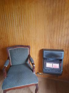 une chaise assise dans une pièce avec fenêtre dans l'établissement La casona de don Juan, à Coyhaique