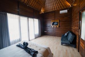 - une chambre avec un lit et une chaise dans l'établissement The Akasea Villa Bali, à Ungasan