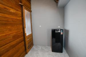 Cette chambre dispose d'une porte en bois et d'un réfrigérateur. dans l'établissement The Akasea Villa Bali, à Ungasan