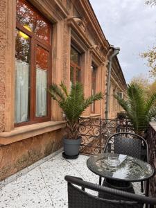 un patio con mesa y sillas en un edificio en Hotel Memoire Kutaisi, en Kutaisi