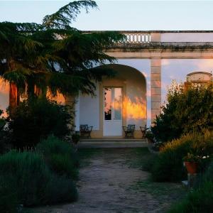 une maison avec une porte voûtée et un coucher de soleil dans l'établissement Agriturismo Villa Coluccia, à Martano