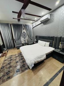 una camera con letto bianco e soffitto di Madcrew Lodge a Islamabad