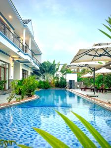 uma piscina num resort com um guarda-sol em Gia An Hung Guest House em Mui Ne