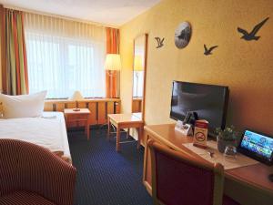 Pokój hotelowy z łóżkiem i biurkiem z komputerem w obiekcie Hotel Am Markt & Brauhaus Stadtkrug w mieście Ueckermünde